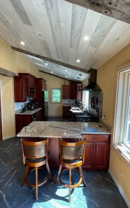 Fully renovated kitchen with vaulted wood ceiling, recessed lighting, cherry cabinets, granite countertops, and modern appliances.